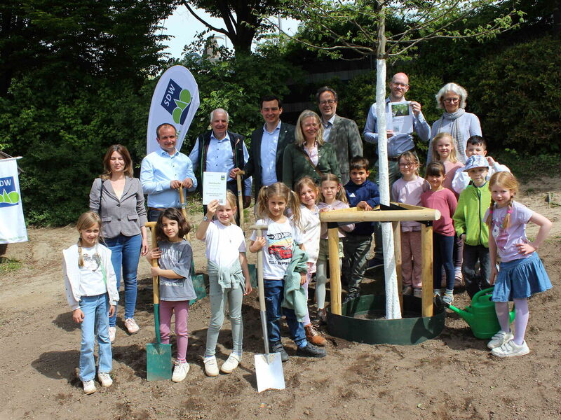 Initiatoren und Gäste der Pflanzaktion auf dem Schulhof der Evangelischen Grundschule Bensberg mit Schulkindern