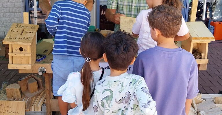 Kinder basteln am Stand der SDW Vogelhäuschen