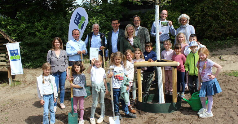 Initiatoren und Gäste der Pflanzaktion auf dem Schulhof der Evangelischen Grundschule Bensberg mit Schulkindern