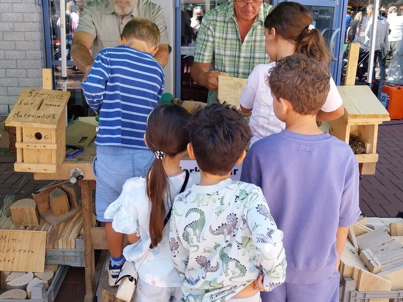 Kinder basteln am Stand der SDW Vogelhäuschen